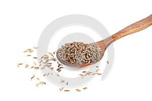 Dried cumin seeds on wooden spoon on white background.