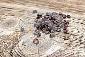 Dried currants on a wooden chopping board.