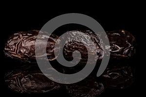 Dried date fruit isolated on black glass