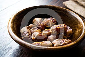 Dried date palm fruits or kurma, ramadan ramazan Medjool food in wooden bowl.