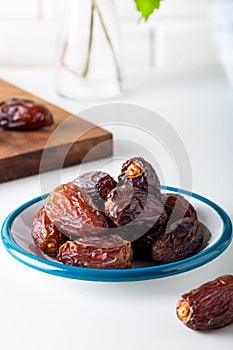 Dried dates in the bowl on white background.