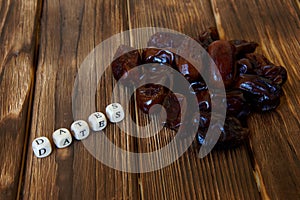 Dried dates lie on a wooden table, next to the explanatory inscription