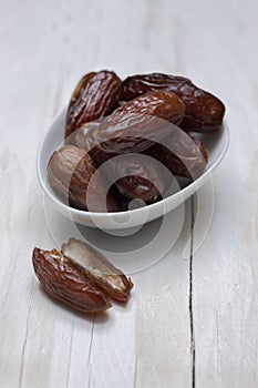 Dried dates on white wooden background