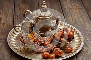 Dried dates on a wooden table in silver dishes close-up. Dates dried dried fruits in the diet chelovenka. Dates.