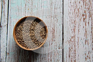 Dried fennel seeds in a wooden bowl .