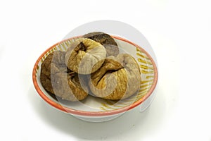 Dried figs on a ceramic saucer isolated on white background. Energy and fiber natural source. Dieting food photo