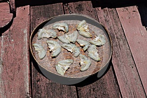 Dried fish fillet on wooden background. Snack on fish with beer, Pieces of salt cod fish. Slices of stockfish on wooden plate.