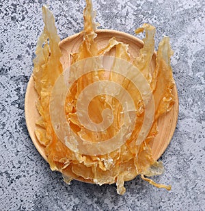 Dried fish maw on wooden table.