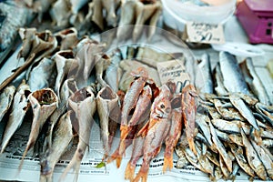 Dried fish on rope at stall on summer market for sale. Salted local seafood. Fishing concept.