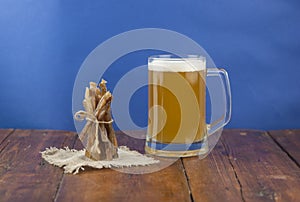 Dried fish in the shape of a straw with beer glass on wooden table. Salted fish delicacies on a table. Close-up