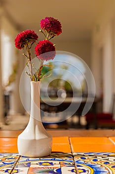 Dried flowers in ceramic vase on table with arabic ornament