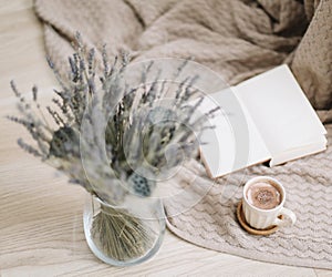 Dried flowers and a cup of cappuccino  with book on wooden background. top view. flatlay