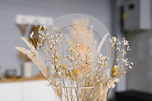 Dried flowers in a yellow vase close-up. Cozy home decor
