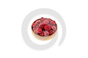 Dried freeze dried raspberries in wooden bowl on white background. Selective focus, copy space. Dehydrated raspberry berries.