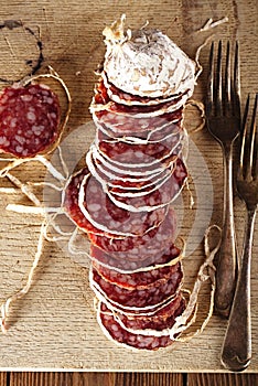 Dried french sausages salami on wooden platter