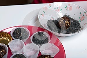 Dried fruit sweets. Balls of prunes, dates and coconut. With a sprinkle of black sesame powder