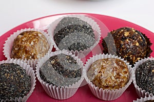 Dried fruit sweets. Balls of prunes, dates and coconut. With a sprinkle of black sesame powder