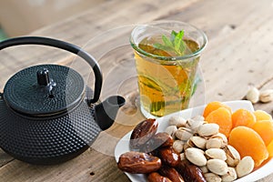 Dried fruit tray with tea glass on wooden background. Copy space.