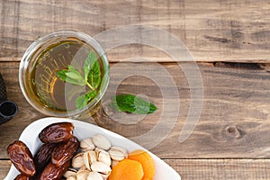 Dried fruit tray with tea glass on wooden background. Copy space