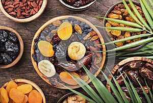 Dried fruits bowl. Healthy food snack: sun dried organic mix of apricots, figs, raisins, dates and other on wooden table, top view