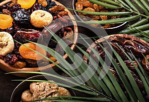 Dried fruits bowl. Healthy food snack: sun dried organic mix of apricots, figs, raisins, dates and other on wooden table, top view