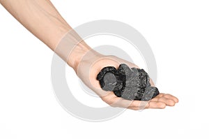 Dried fruits and cooking theme: man's hand holding a black Dried prunes isolated on a white background in studio