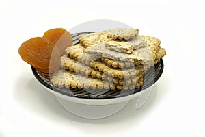 Dried fruits and digestive biscuits on a ceramic saucer isolated on white background. Energy and fiber natural source. Dieting photo