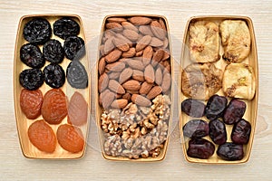 Dried fruits, fresh dates and nuts on the wooden trays