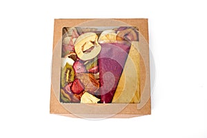 Dried fruits and fruit pastille in craft paper box with transparent lid