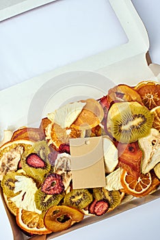 Dried fruits in open craft paper box with transparent lid