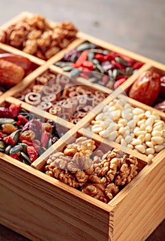 Dried fruits, various nuts and seeds in old wooden box.