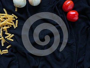 Dried Fusilli,Tomato,Black fabric background,Use as wallpaper