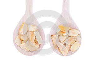 Dried garlic flakes in wooden spoons