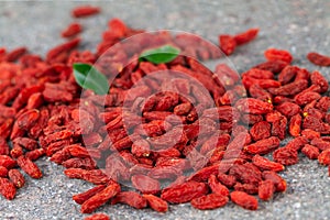 Dried Goji berries scattered on gray stone background