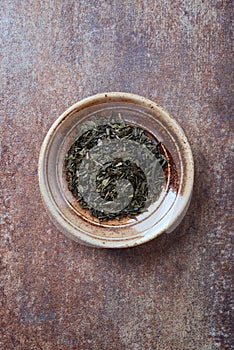 Dried Green Tea  sencha Leaves on rustic stone Background.