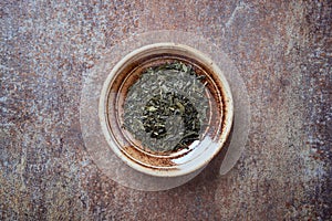 Dried Green Tea  sencha Leaves on rustic stone Background
