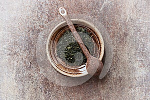 Dried Green Tea  sencha Leaves on rustic stone Background