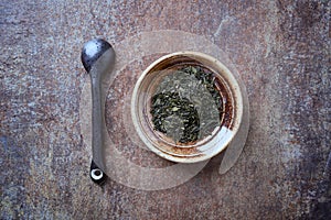 Dried Green Tea  sencha Leaves on rustic stone Background