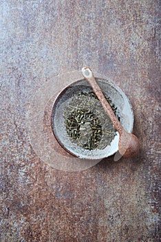 Dried Green Tea  sencha Leaves on rustic stone Background.