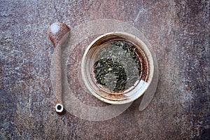 Dried Green Tea  sencha Leaves on rustic stone Background.