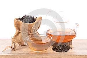 Dried green tea and tea on wood table isolated on white background