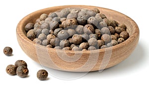 Dried herb, allspice in the wooden plate. isolated on white