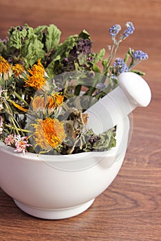 Dried herbs and flowers in white mortar, herbalism, decoration