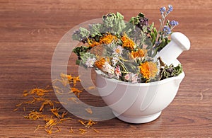 Dried herbs and flowers in white mortar, herbalism, decoration photo