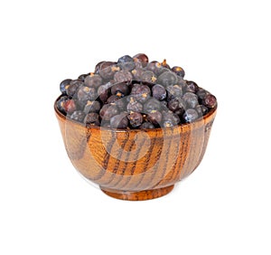 Dried juniper berries in wooden bowl isolated on white