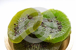 Dried kiwi fruit isolated on white background. Sweet and sour dried kiwi in a wooden bowl.