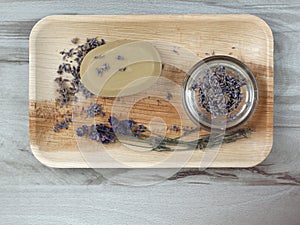 Dried lavender, lavender flowers and soap in a bright dish on a wooden background