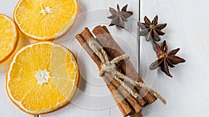 Dried lemon slices, anise starlets and cinnamon on a light wooden table