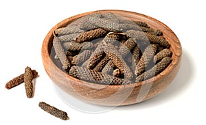 Dried long pepper, piper longum in the wooden plate, isolated on white