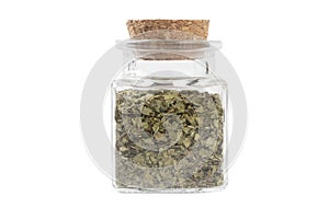 Dried lovage herb in a glass jar isolated on white background. spices and food ingredients